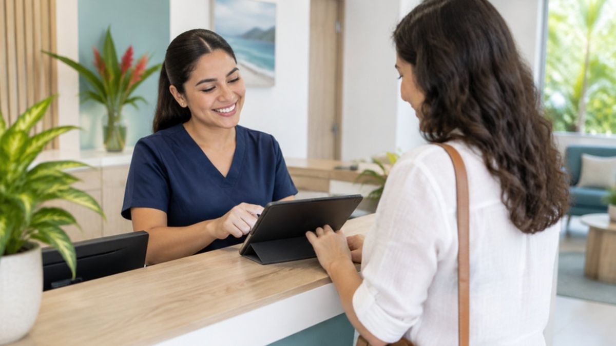 Recepcionista atendiendo a una paciente con una tableta